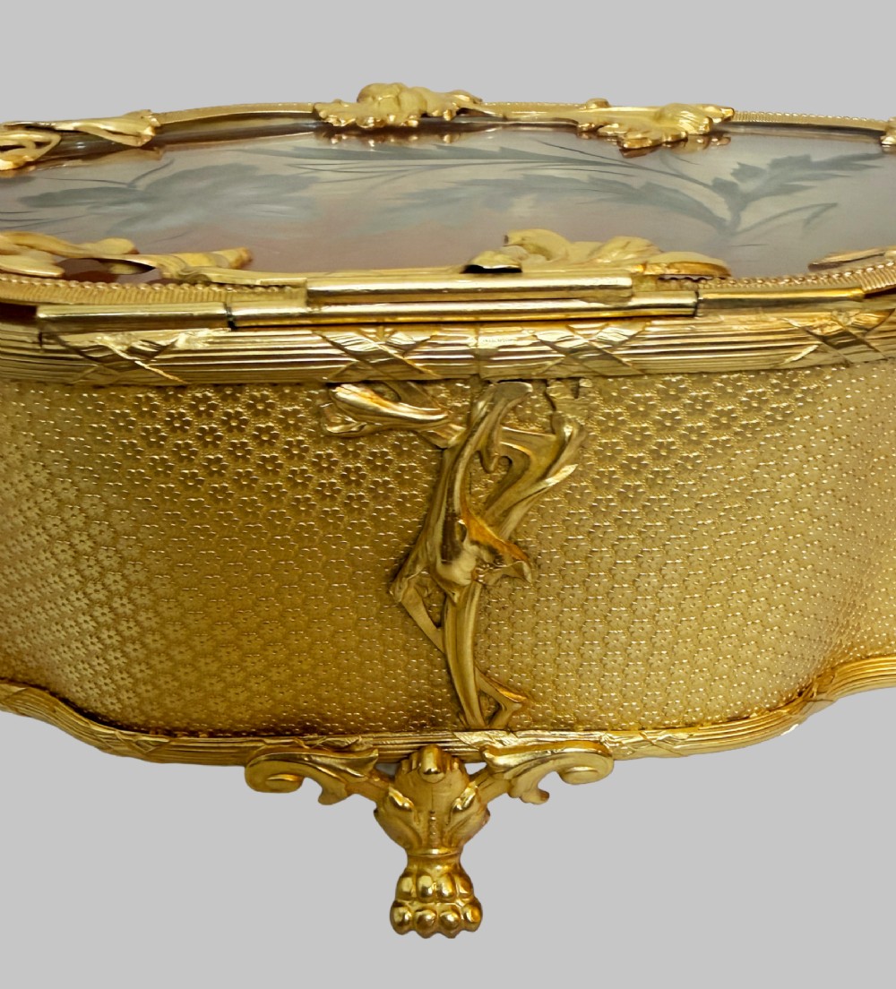 An oval nineteenth-century gilt bronze jewellery box featuring textured foliate relief work, scroll feet, and an etched glass lid. View VII