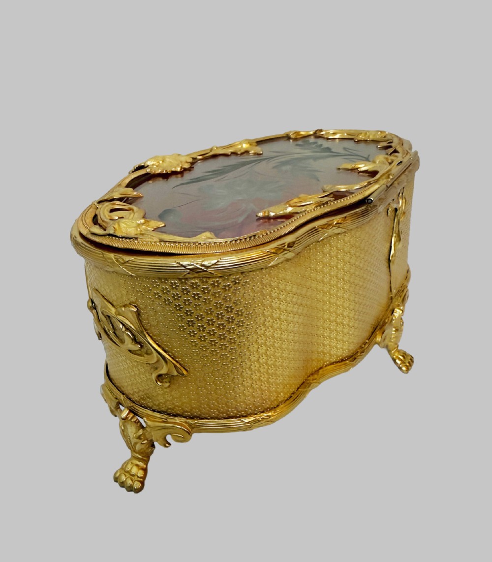 An oval nineteenth-century gilt bronze jewellery box featuring textured foliate relief work, scroll feet, and an etched glass lid. View VIII