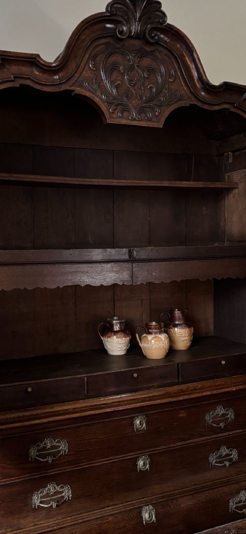 An 18th-century Dutch oak linen press featuring an arched pediment, two carved panel doors, three lower drawers, and brass handles. View X