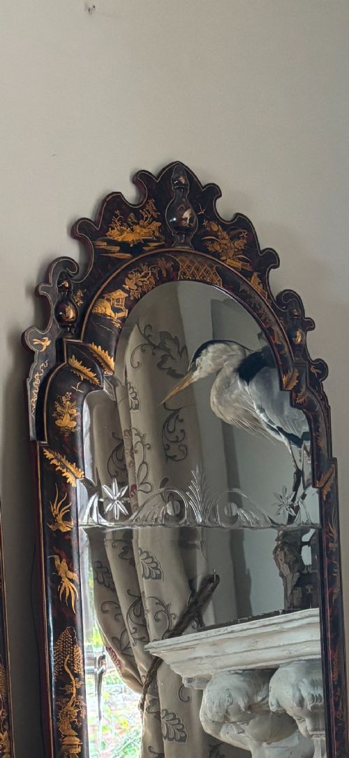 A pair of tall arched Queen Anne style wall mirrors featuring black japanned frames decorated with gilded chinoiserie motifs and cut glass crests. View IX