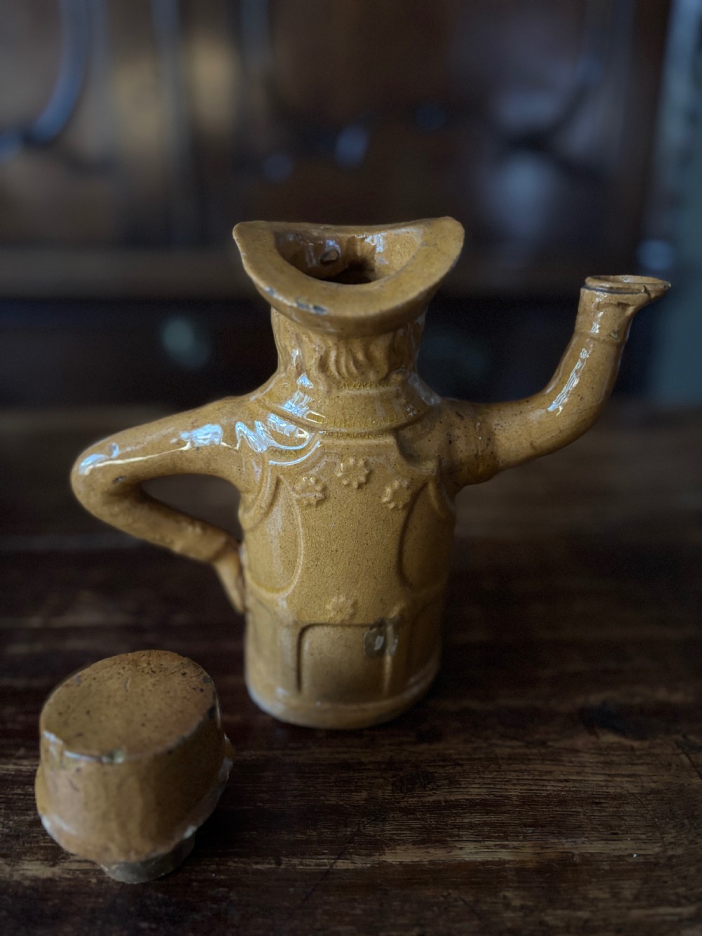 A Victorian treacle-glazed yellowware teapot moulded into the seated figure of John Bull wearing a top hat and waistcoat. View II