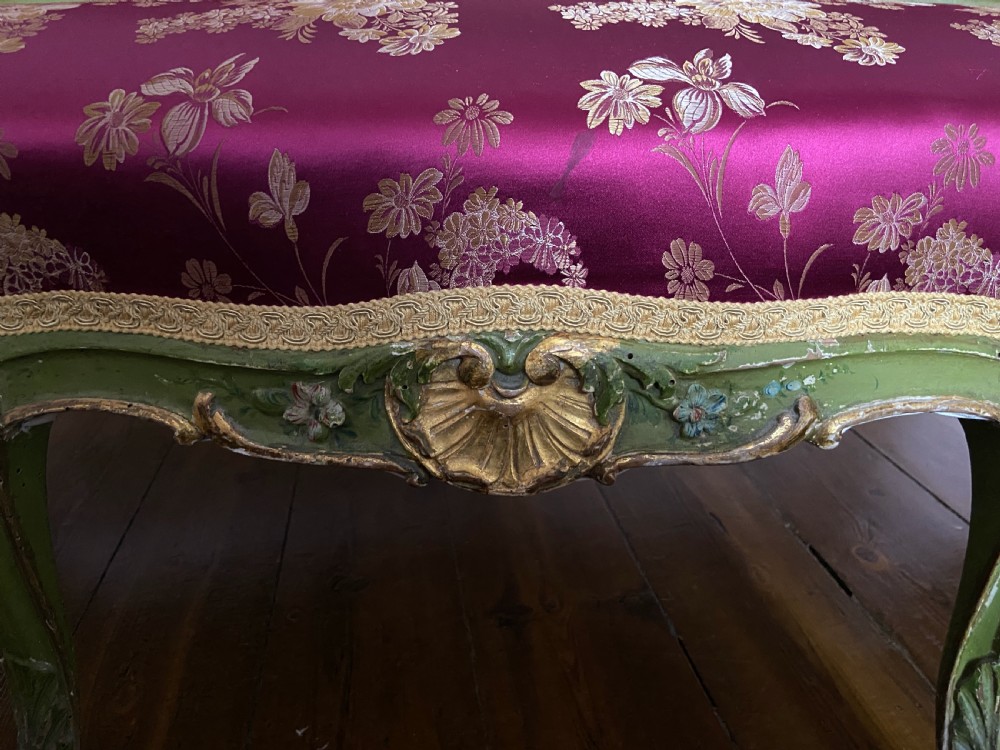 An early 19th-century Italian Venetian sofa featuring a carved green and gold polychrome frame with cabriole legs, upholstered in a rich magenta floral damask fabric. View II