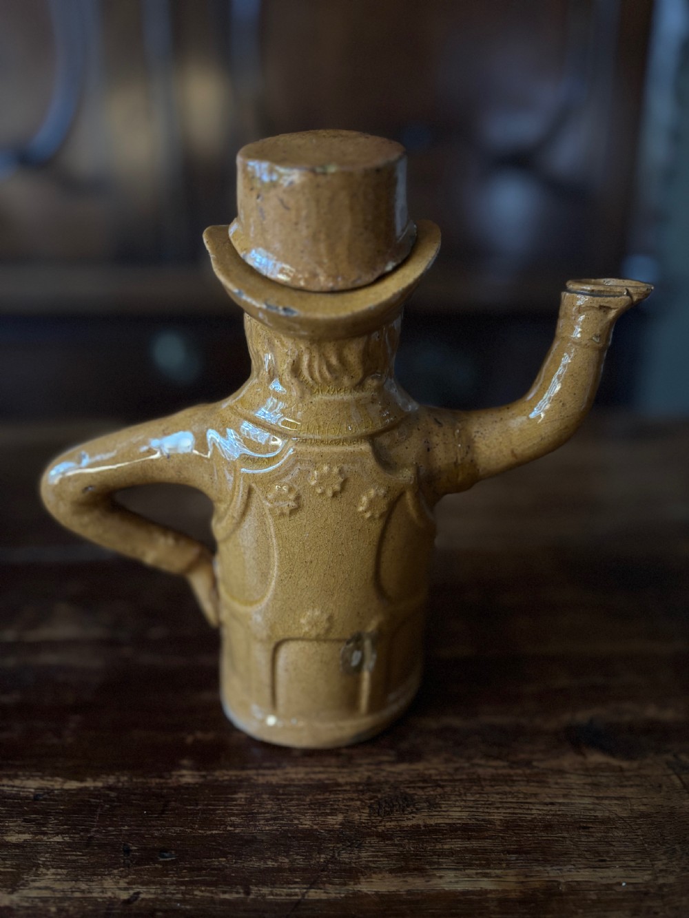 An antique mid-nineteenth century ochre-yellow glazed earthenware teapot sculpted in the shape of John Bull wearing a top hat and coat. View III