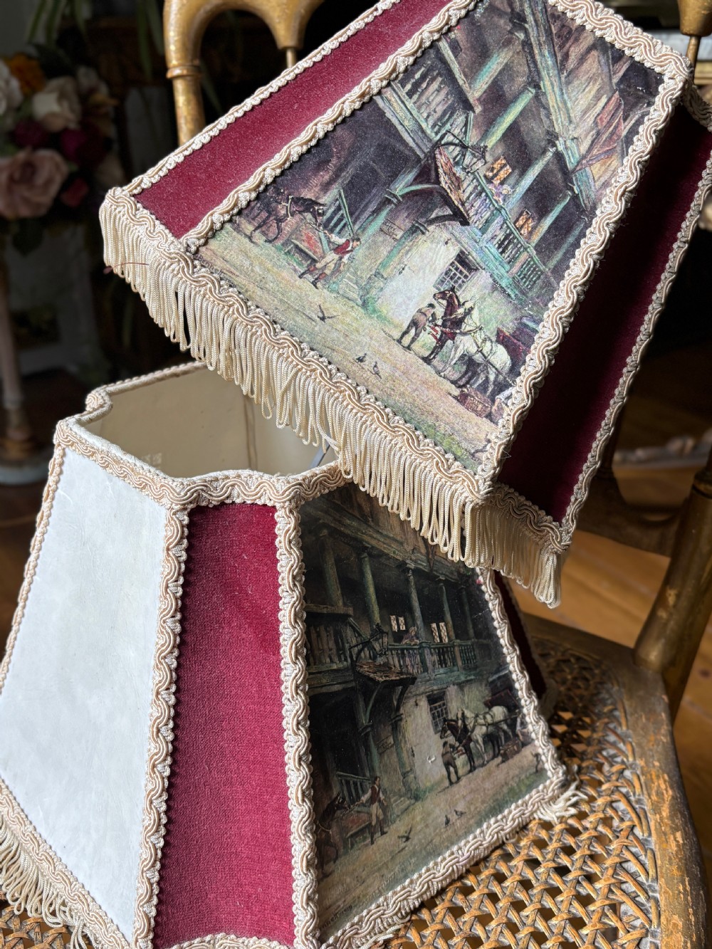A pair of 1930s hexagonal lampshades featuring printed tavern scenes, deep burgundy fabric panels, braid trim, and lower fringe. View IV