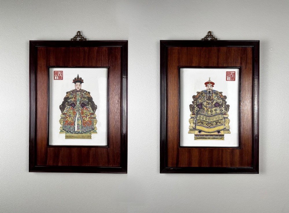 A pair of framed Chinese porcelain wall plaques painted with portraits of Emperor Kangxi and Empress Xiaozhuang Wen seated on dragon thrones.