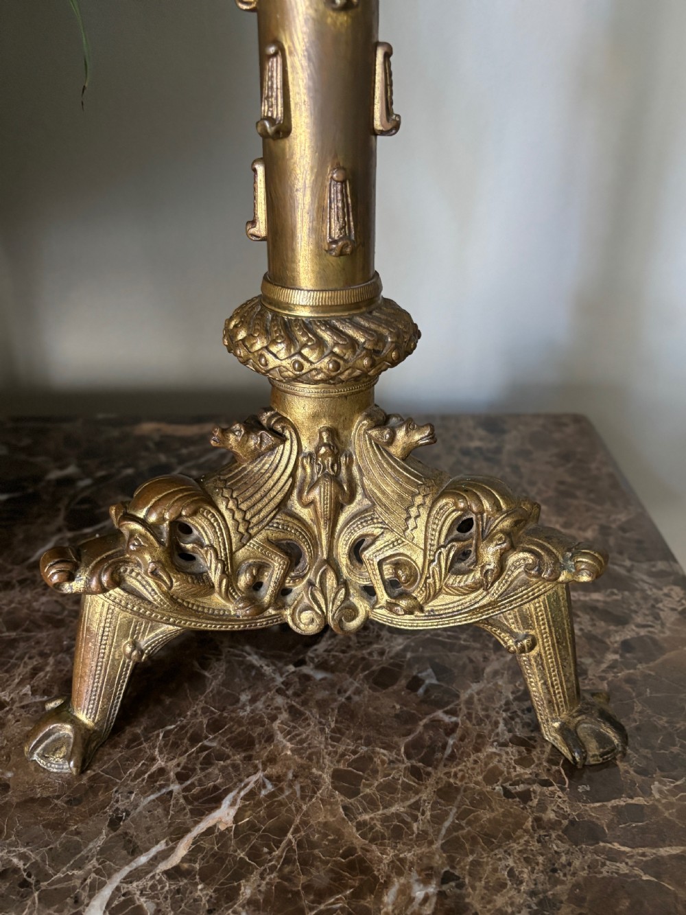 A pair of large French 19th-century gilt bronze candlesticks featuring ornate tripod bases, detailed knapped columns, and wide drip pans. View II