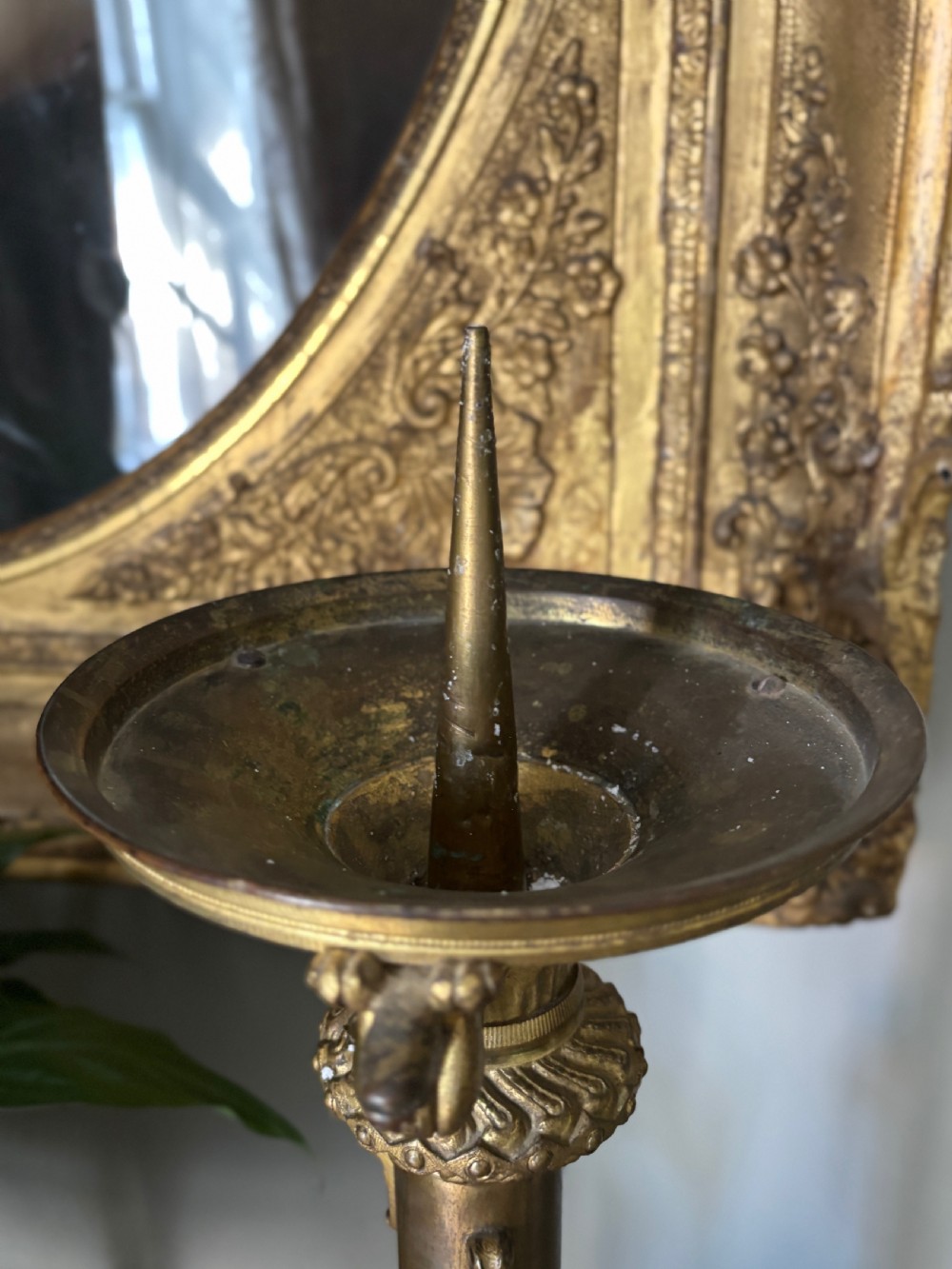 A pair of large French 19th-century gilt bronze candlesticks featuring ornate tripod bases, detailed knapped columns, and wide drip pans. View IV