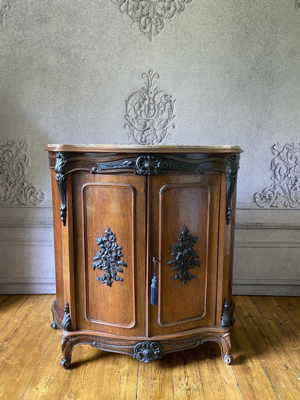 A mid-nineteenth-century French rosewood pier cabinet featuring curved side panels, ebonised carved mounts, twin front doors, and a marble surface. View II