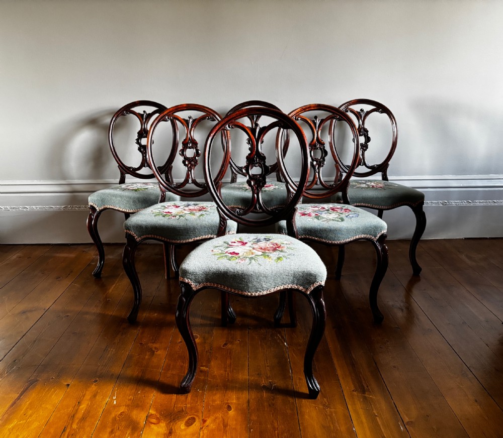 A set of six Victorian rosewood dining chairs with carved balloon backs and duck egg blue needlepoint floral seats. View II