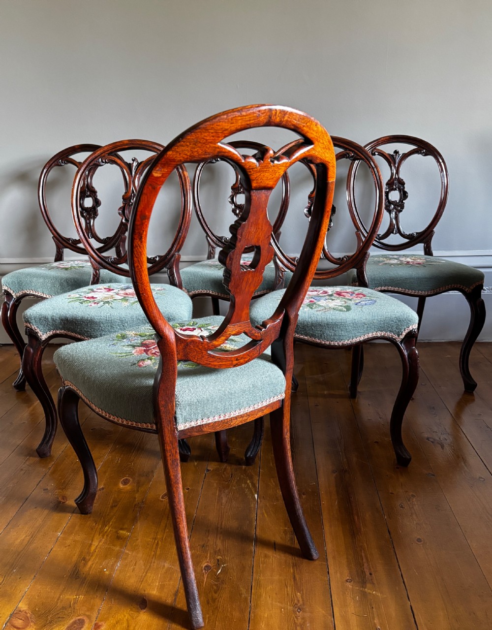 A set of six Victorian rosewood dining chairs with carved balloon backs and duck egg blue needlepoint floral seats. View IX