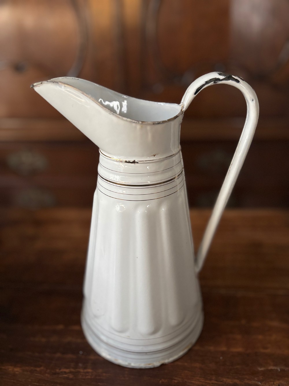 A tall white French enamelware water jug featuring a fluted lower body, thin gold gilt line details, an arched handle, and a raised spout. View II