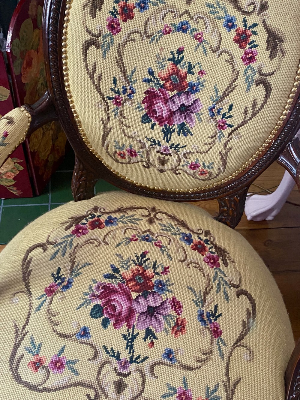 A French Louis XVI style open armchair featuring a dark carved wood frame, fluted legs, and yellow needlepoint upholstery decorated with floral motifs. View II
