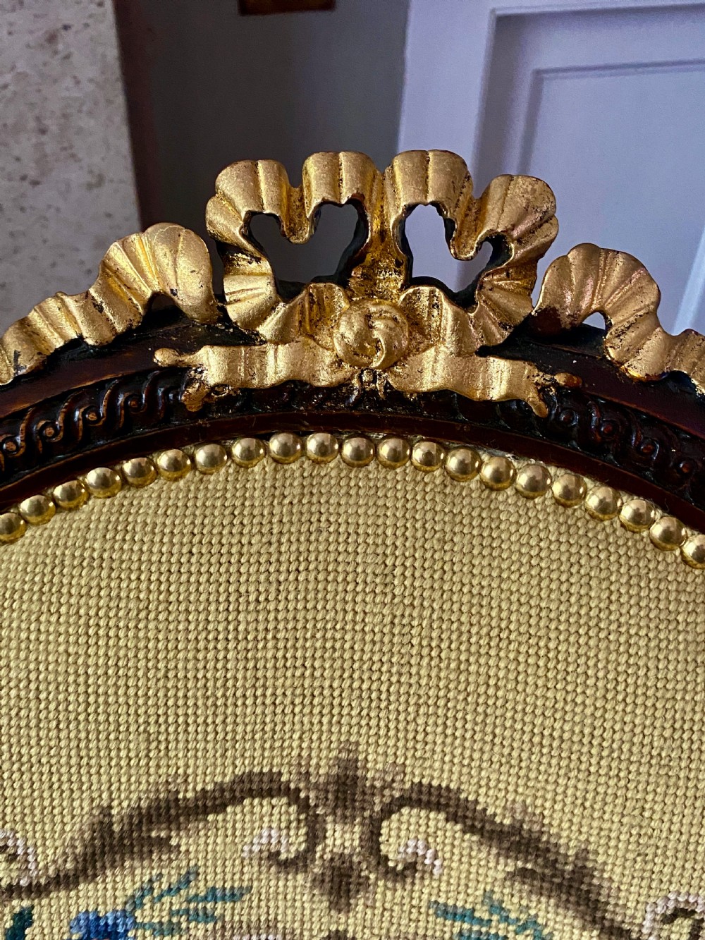 A French Louis XVI style open armchair featuring a dark carved wood frame, fluted legs, and yellow needlepoint upholstery decorated with floral motifs. View V