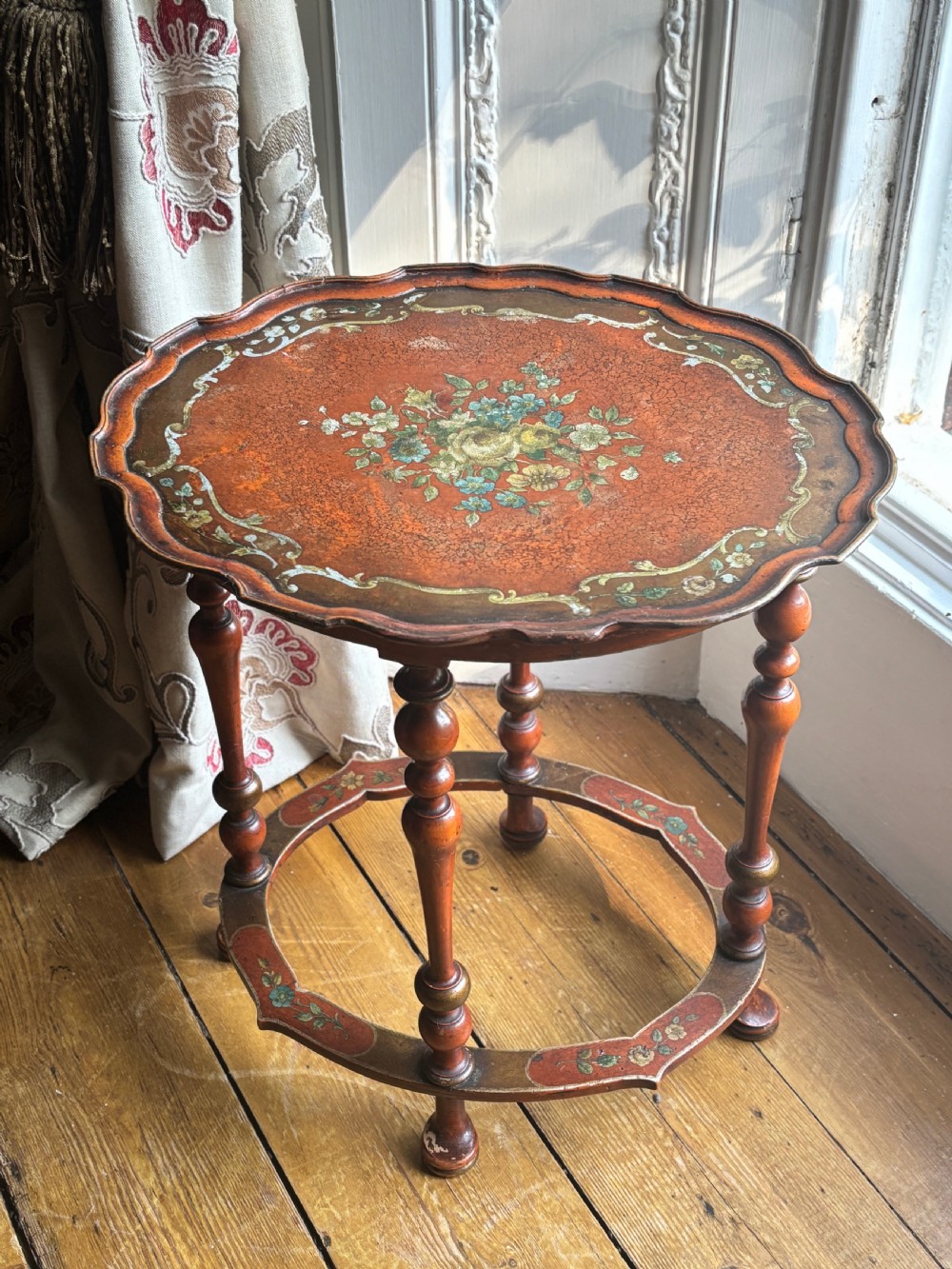 A late nineteenth-century Italian polychrome occasional table with a scalloped tray top, central painted floral design, turned legs, and an oval stretcher. View II