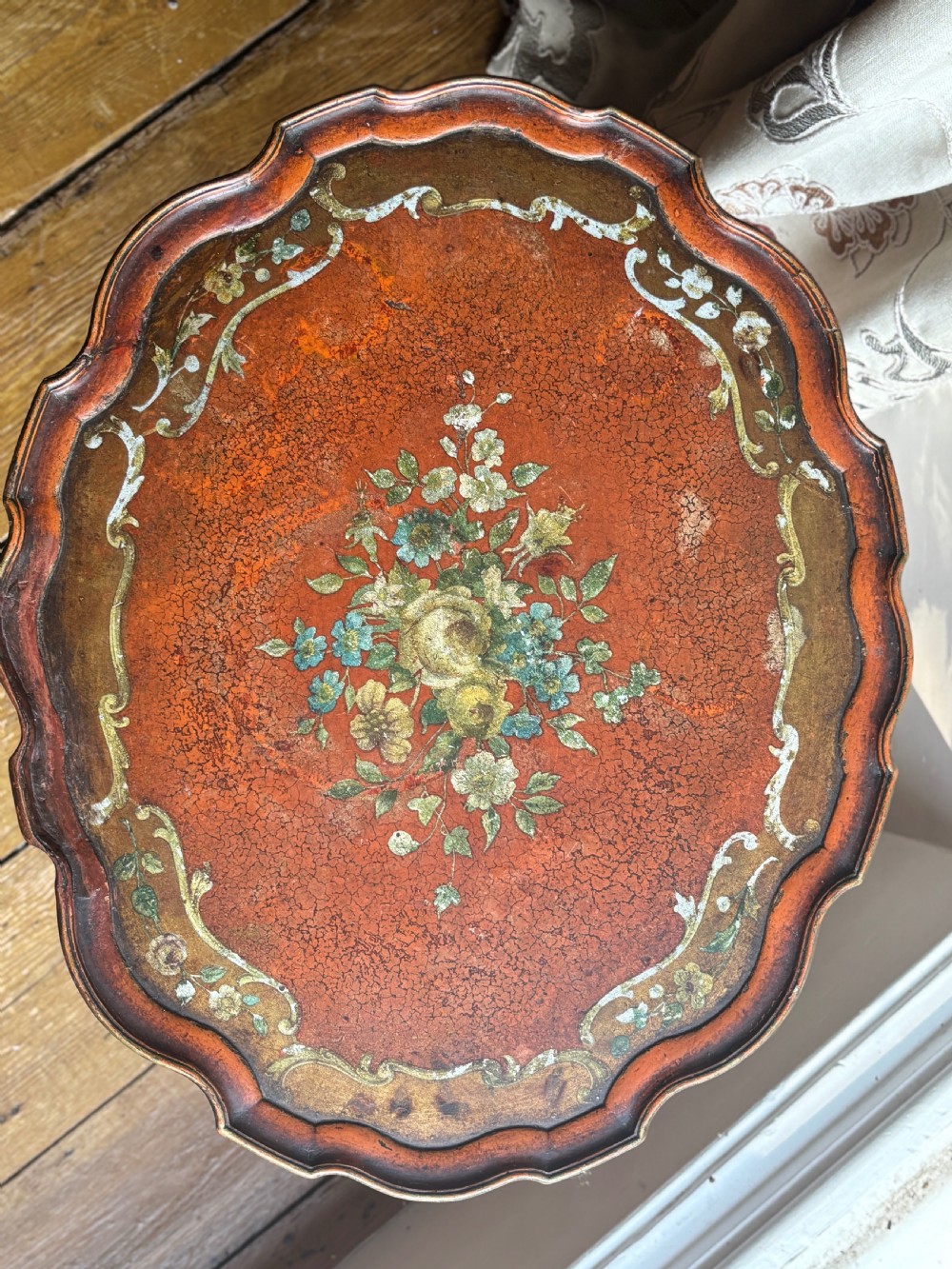 A late nineteenth-century Italian polychrome occasional table with a scalloped tray top, central painted floral design, turned legs, and an oval stretcher. View IV