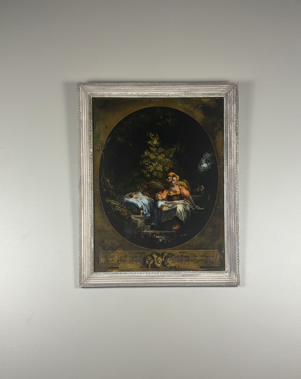 A Georgian reverse print on glass displaying a figure scene inside an oval vignette within a silvered moulded frame. View VI