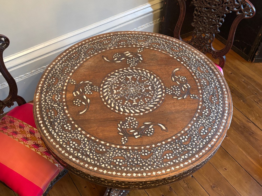A 19th-century round Anglo-Indian pedestal table featuring mother-of-pearl inlay across the circular top, apron, turned column, and tripod base. View XII