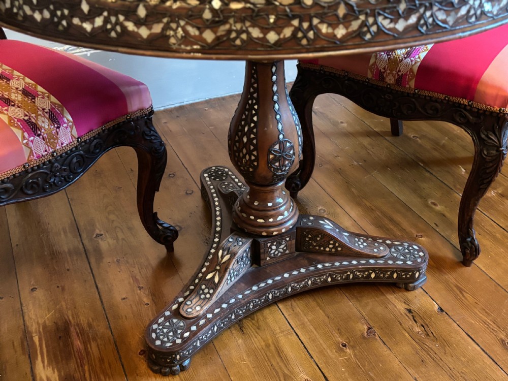 A 19th-century round Anglo-Indian pedestal table featuring mother-of-pearl inlay across the circular top, apron, turned column, and tripod base. View II