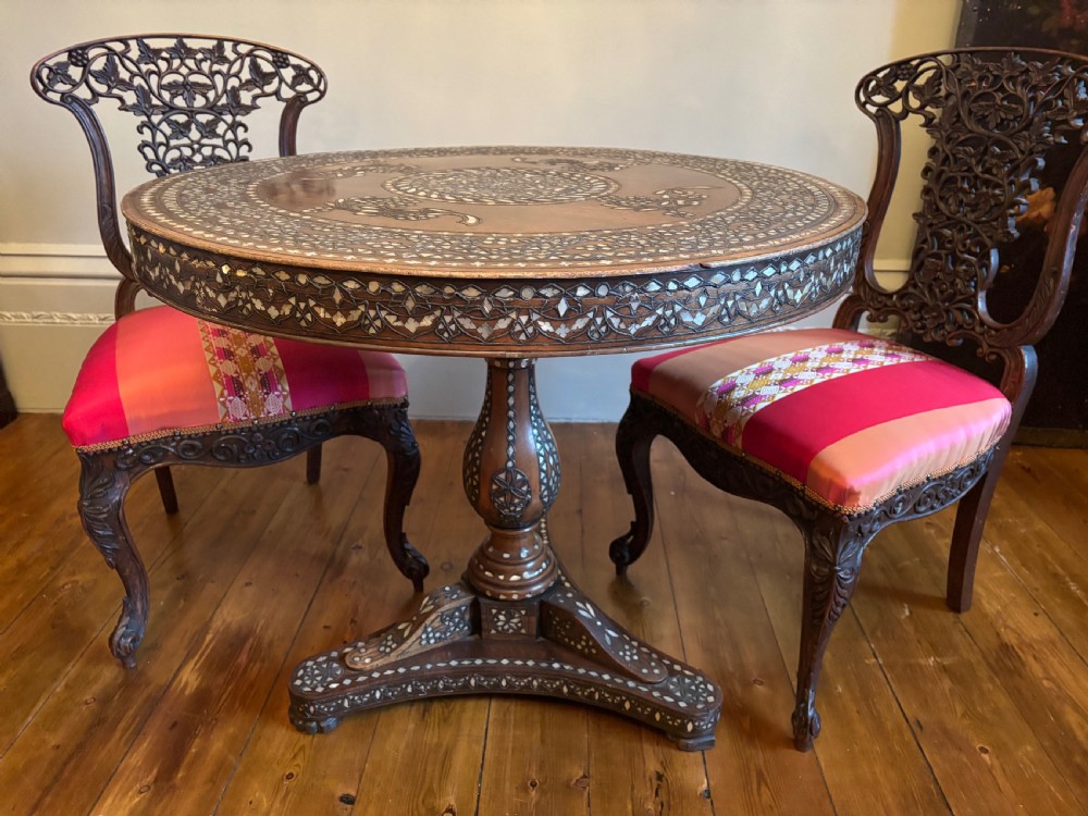 A 19th-century round Anglo-Indian pedestal table featuring mother-of-pearl inlay across the circular top, apron, turned column, and tripod base. View V