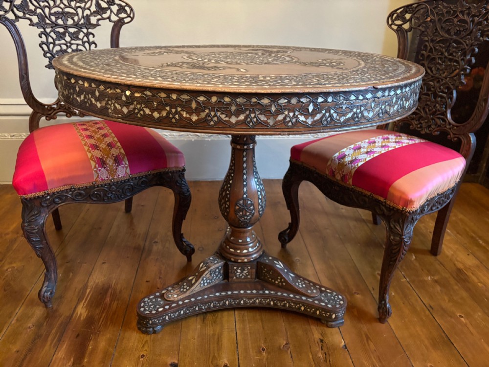 A 19th-century round Anglo-Indian pedestal table featuring mother-of-pearl inlay across the circular top, apron, turned column, and tripod base. View VI