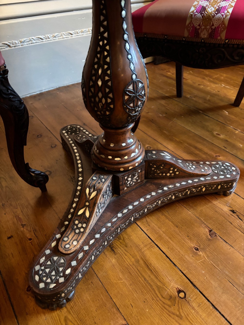 A 19th-century round Anglo-Indian pedestal table featuring mother-of-pearl inlay across the circular top, apron, turned column, and tripod base. View VII