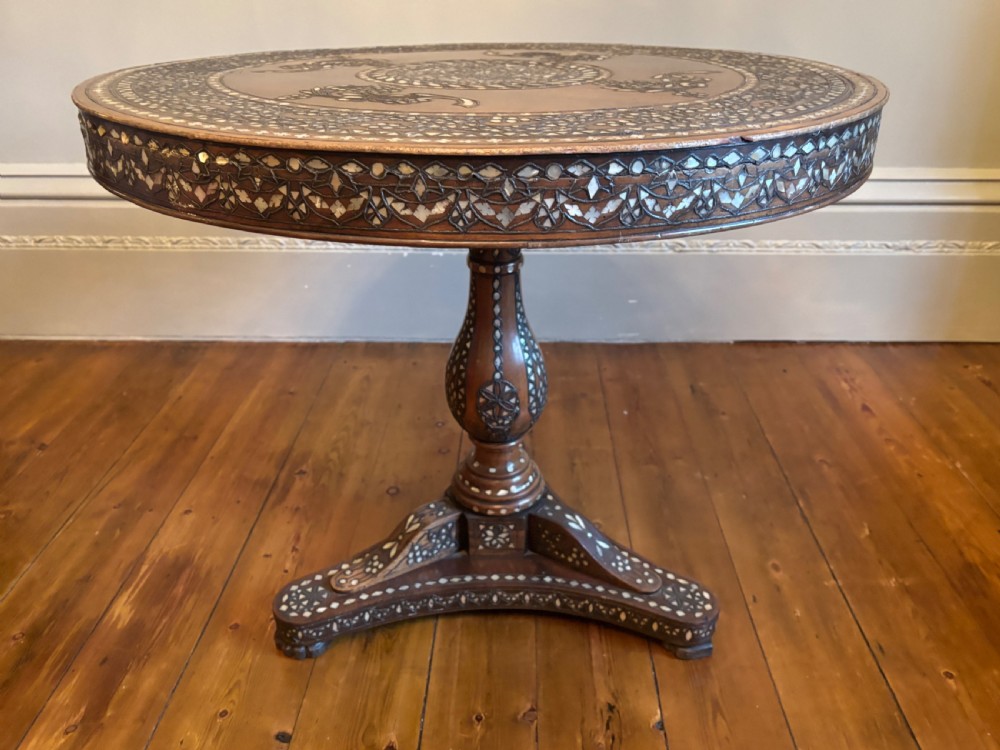 A 19th-century round Anglo-Indian pedestal table featuring mother-of-pearl inlay across the circular top, apron, turned column, and tripod base. View XI