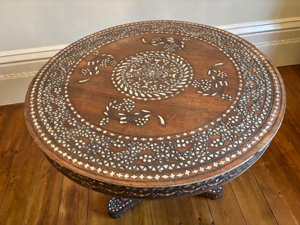 A 19th-century round Anglo-Indian pedestal table featuring mother-of-pearl inlay across the circular top, apron, turned column, and tripod base. View XIV