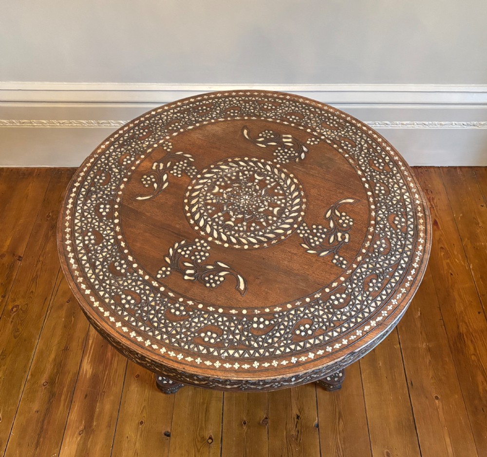 A 19th-century round Anglo-Indian pedestal table featuring mother-of-pearl inlay across the circular top, apron, turned column, and tripod base. View XV