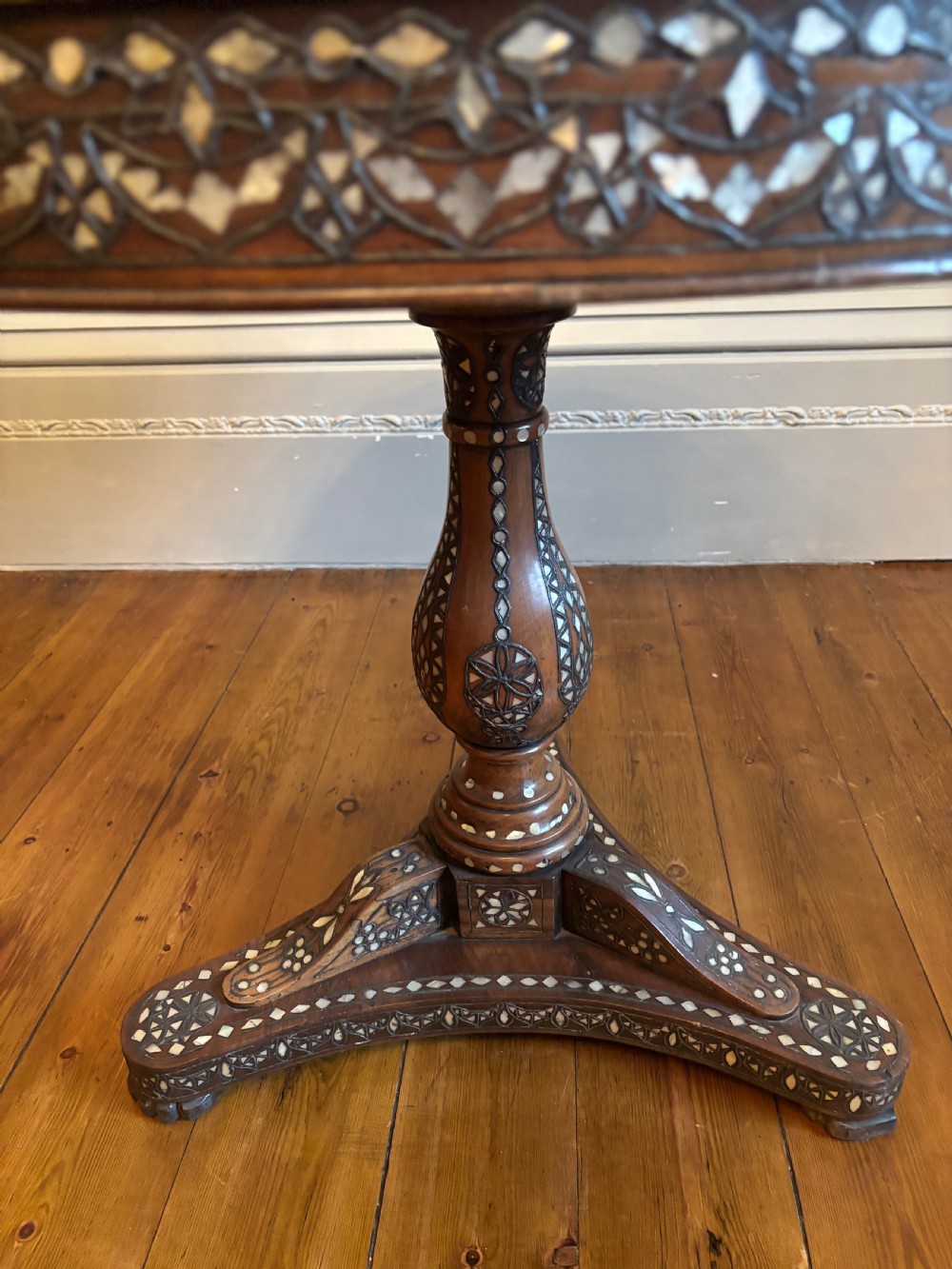 A 19th-century round Anglo-Indian pedestal table featuring mother-of-pearl inlay across the circular top, apron, turned column, and tripod base. View XVIII
