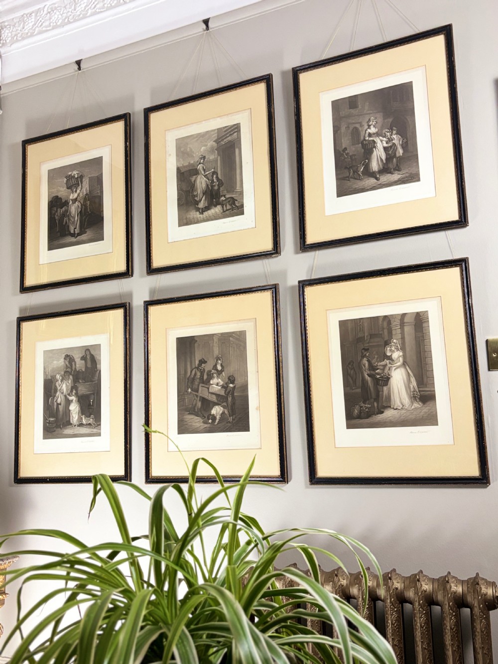 A set of six uniformly framed 19th-century monochrome mezzotint prints depicting figurative street scenes with light cream mounts and dark wood frames. View III