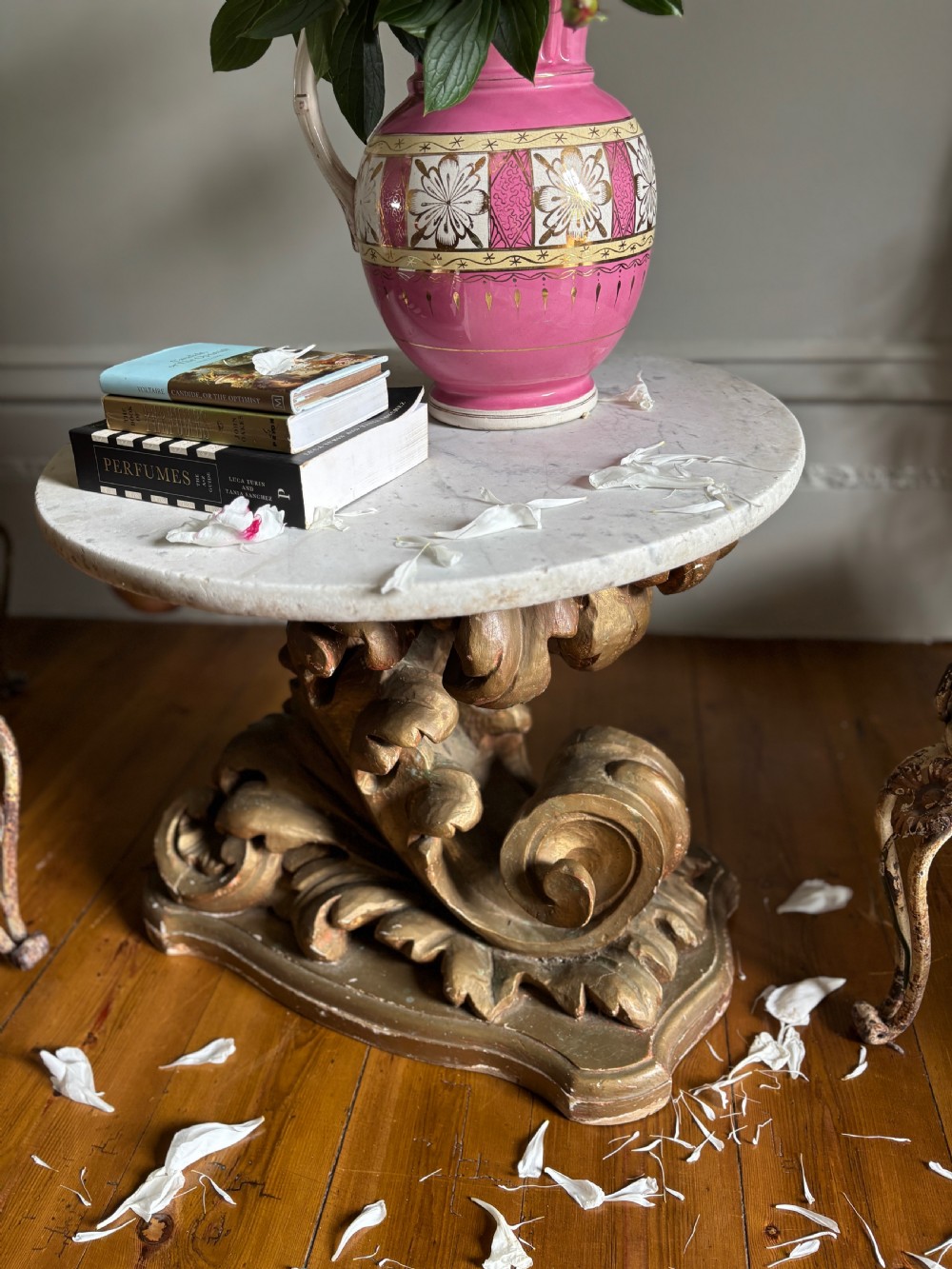 An 18th-century Italian Baroque side table featuring a circular white marble top set upon an ornately carved, gilded limewood base with acanthus leaf scrollwork.