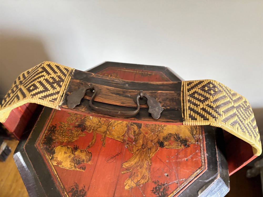 An octagonal red and black lacquered three-tier Chinese dowry basket with an overhead bentwood handle bound in woven cane and panels painted with figures. View VII
