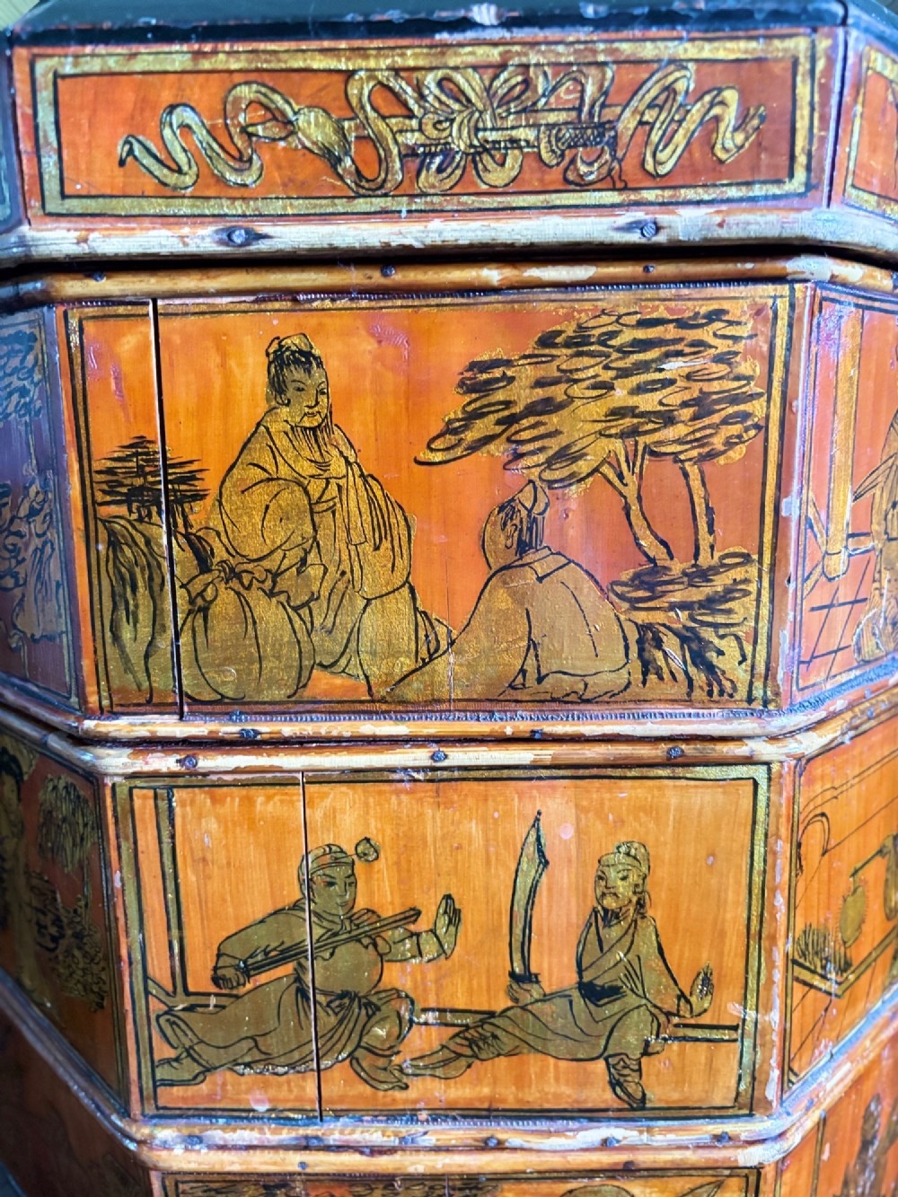 An octagonal red and black lacquered three-tier Chinese dowry basket with an overhead bentwood handle bound in woven cane and panels painted with figures. View VIII