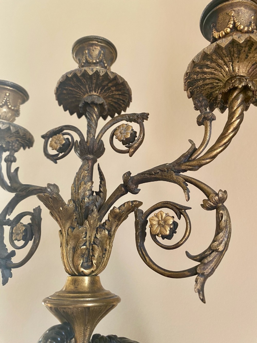 A pair of late Louis XVI style candelabra featuring dark patinated bronze putti holding multi-arm gilt bronze candle holders, mounted on circular fluorspar pedestals with ormolu floral swags. View II