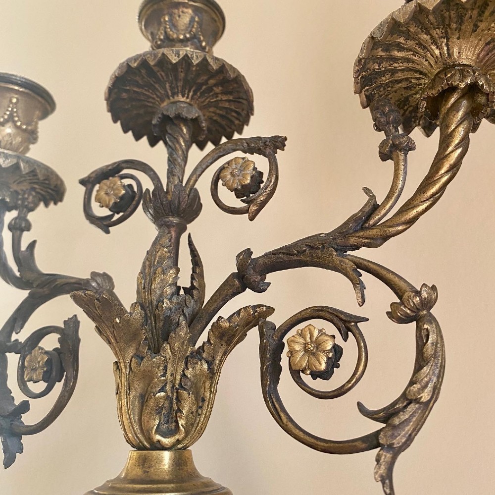 A pair of late Louis XVI style candelabra featuring dark patinated bronze putti holding multi-arm gilt bronze candle holders, mounted on circular fluorspar pedestals with ormolu floral swags. View X