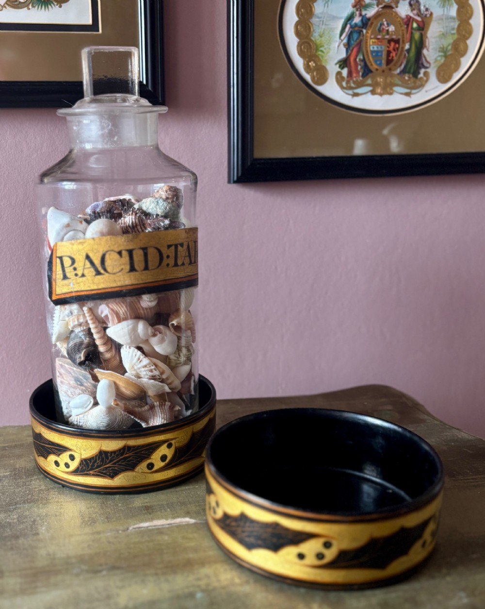 A pair of circular Regency black lacquered papier-mache wine coasters decorated with hand-painted gilded foliage motifs around the outer rim. View II