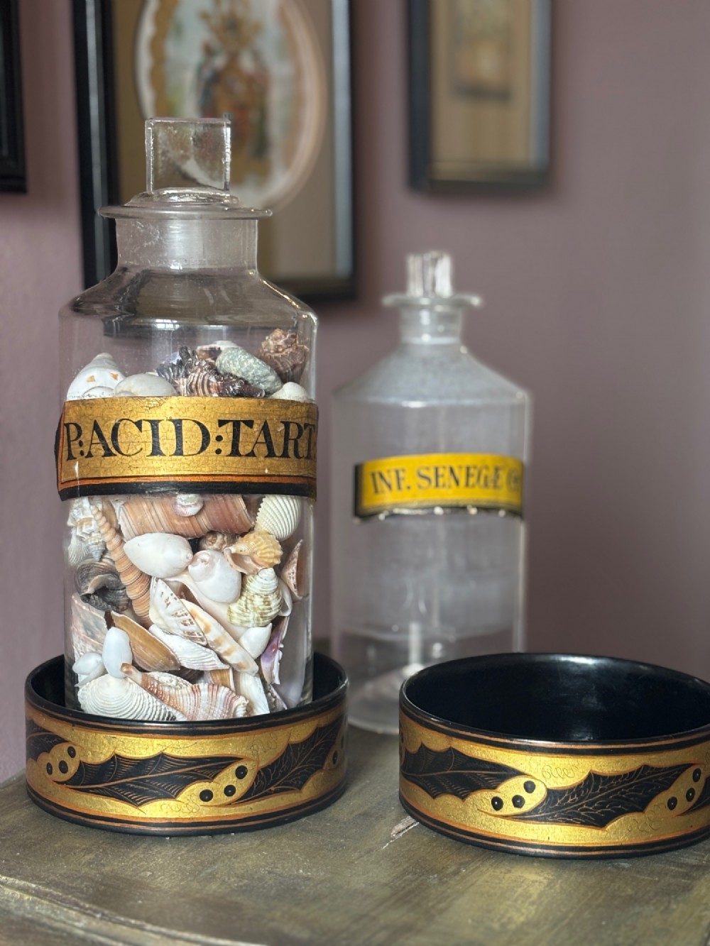 A pair of circular Regency black lacquered papier-mache wine coasters decorated with hand-painted gilded foliage motifs around the outer rim. View IV