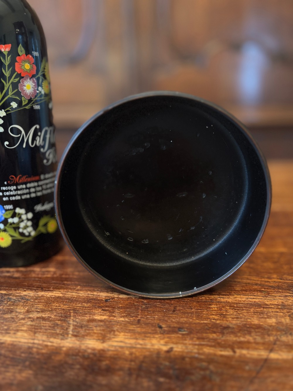 A circular black lacquered antique wine coaster decorated with gold star motifs and vermicelli patterns around the exterior side. View III