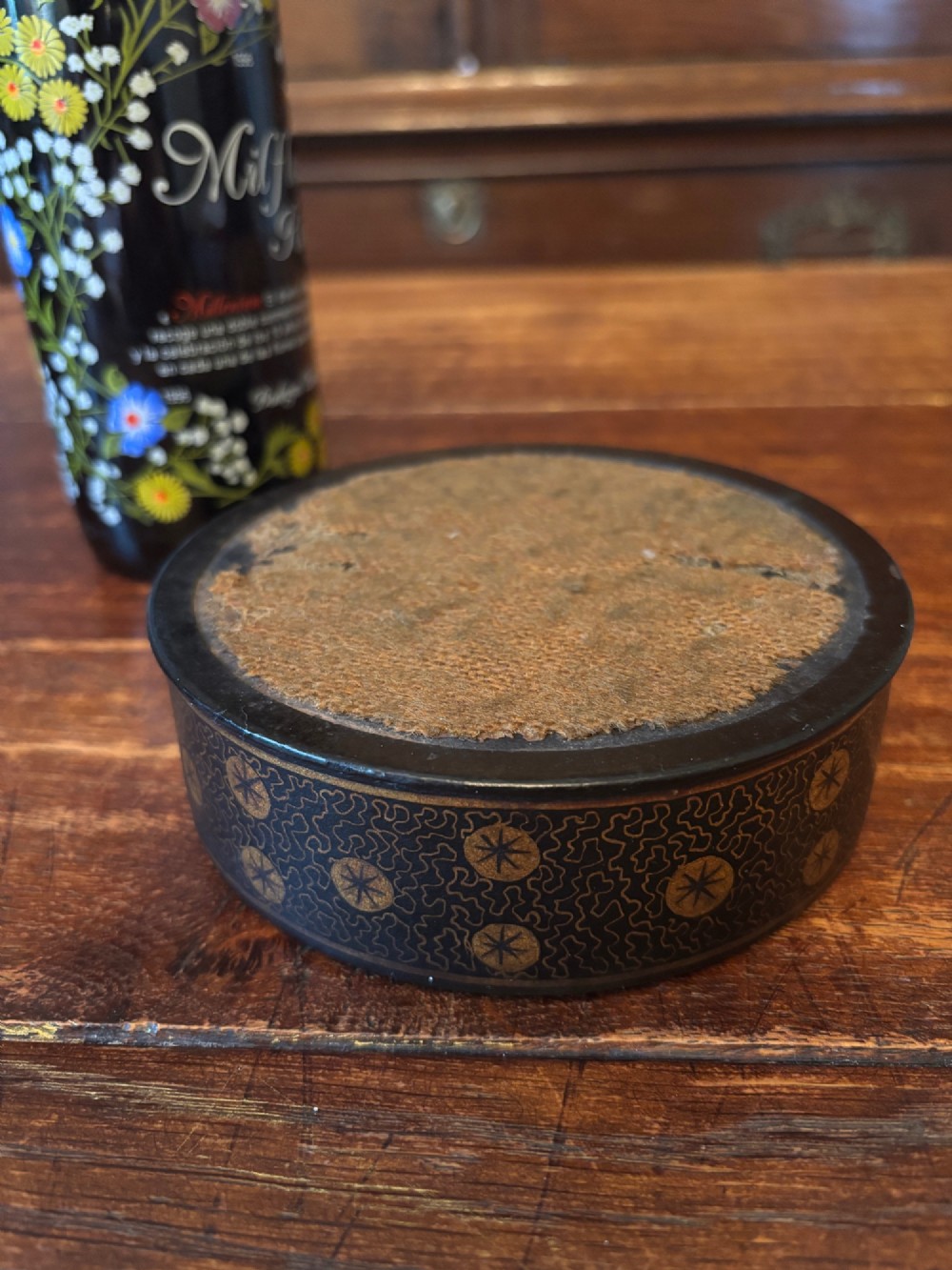 A circular black lacquered antique wine coaster decorated with gold star motifs and vermicelli patterns around the exterior side. View IV