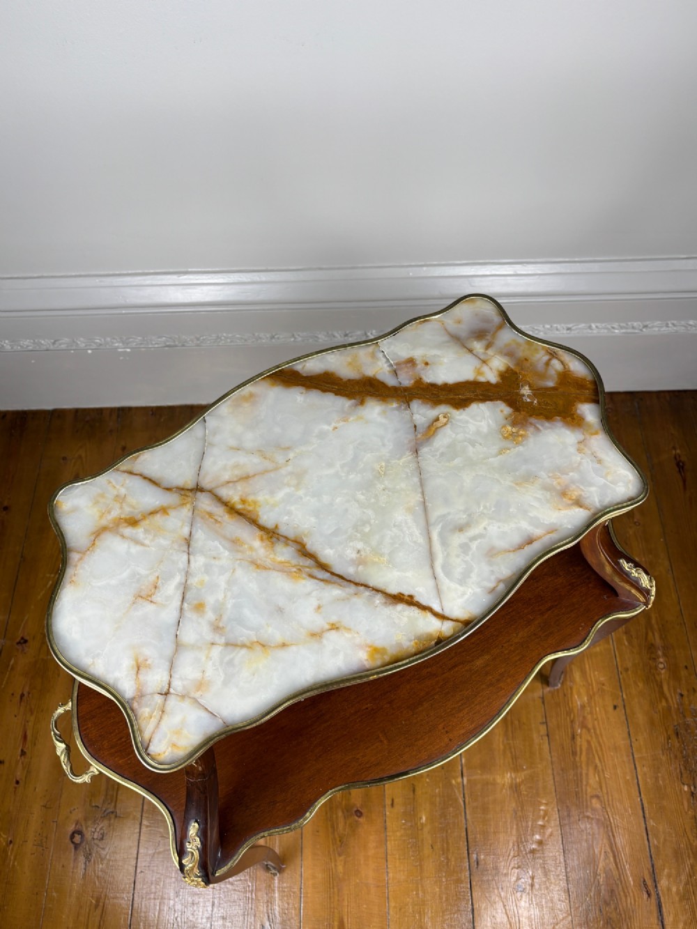 A French Napoleon III style two-tier tea table featuring an onyx inset top shelf, a mahogany lower shelf with side handles, cabriole legs, and gilded bronze mounts. View IV