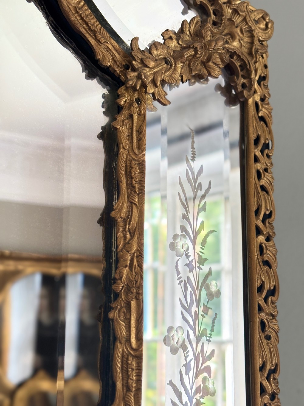 A French Louis XV style wall mirror featuring a gilt bronze frame with a cherub cresting and floral etched glass border plates. View III