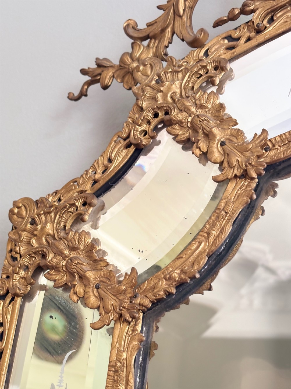 A French Louis XV style wall mirror featuring a gilt bronze frame with a cherub cresting and floral etched glass border plates. View IV