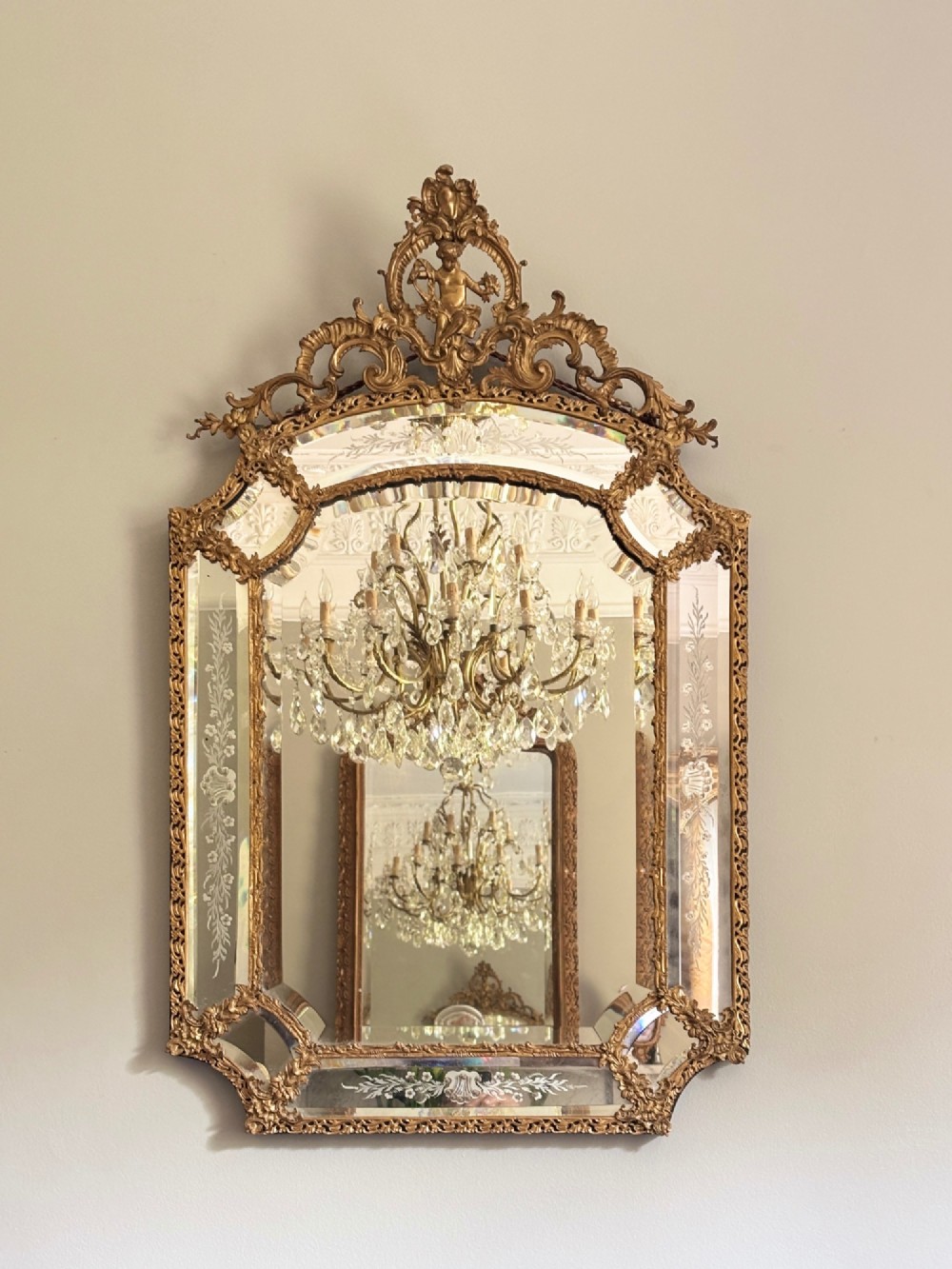A French Louis XV style wall mirror featuring a gilt bronze frame with a cherub cresting and floral etched glass border plates. View VII