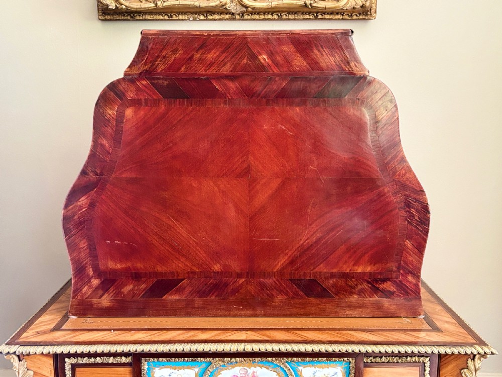 A Louis XV style rosewood desktop cartonnier with curved sides, gold-toned ormolu mounts, and open storage compartments. View IV