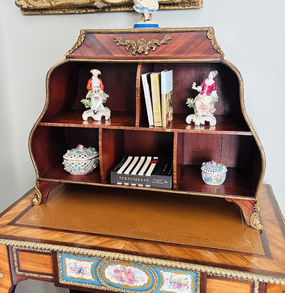 A Louis XV style rosewood desktop cartonnier with curved sides, gold-toned ormolu mounts, and open storage compartments. View V