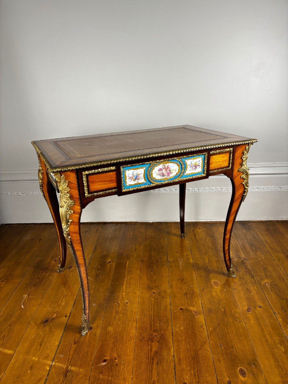 A Louis XV style rosewood writing table featuring cabriole legs, gilt bronze ormolu mounts, and turquoise porcelain plaques. View II