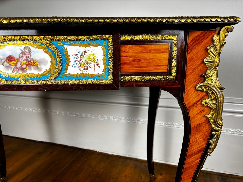 A Louis XV style rosewood writing table featuring cabriole legs, gilt bronze ormolu mounts, and turquoise porcelain plaques. View IX
