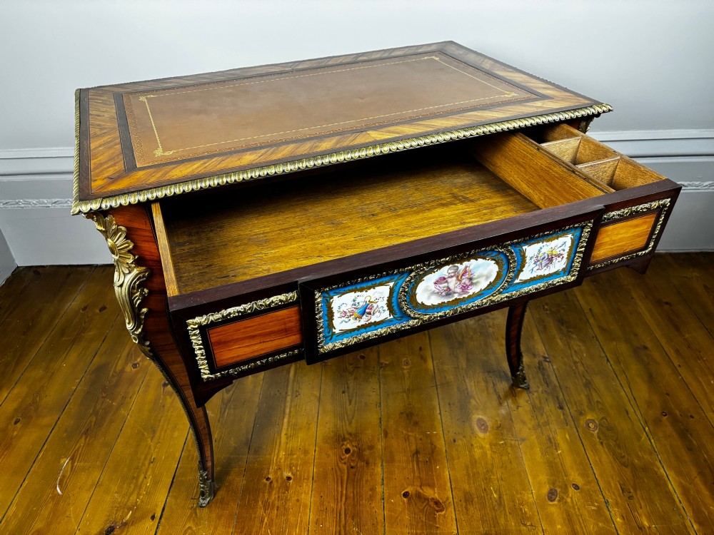A Louis XV style rosewood writing table featuring cabriole legs, gilt bronze ormolu mounts, and turquoise porcelain plaques. View XIV