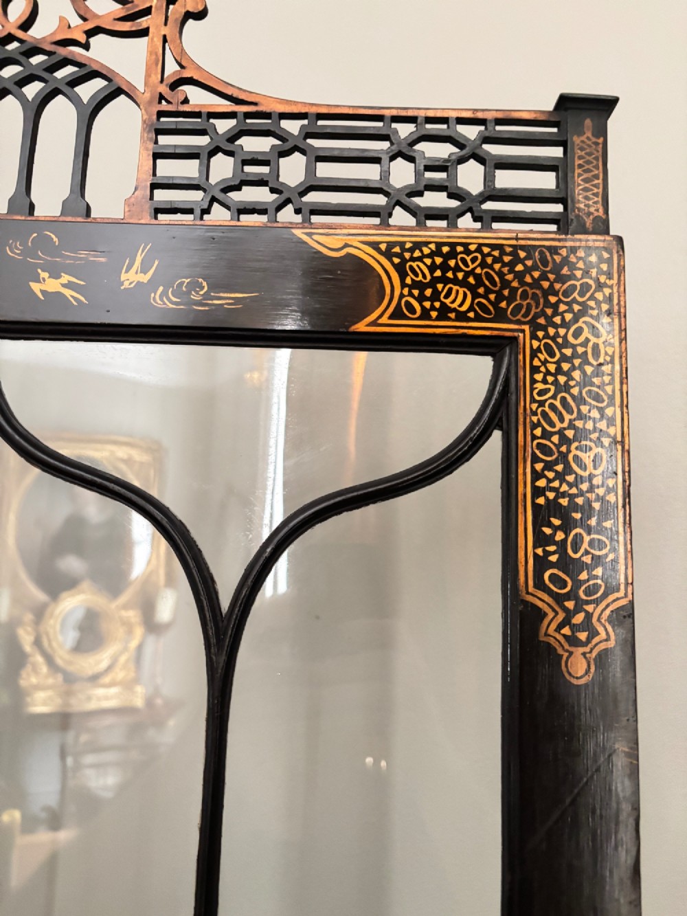 A four-fold black lacquered screen with Chinese Chippendale fretwork crestings, glazed upper panels, and incised gold chinoiserie landscape scenes. View III