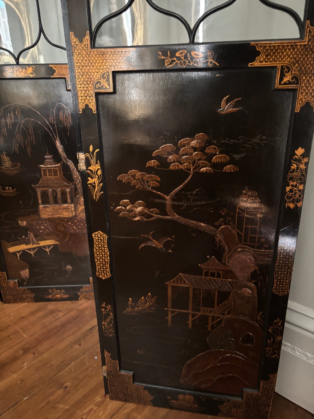 A four-fold black lacquered screen with Chinese Chippendale fretwork crestings, glazed upper panels, and incised gold chinoiserie landscape scenes. View VIII